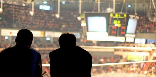 两个人在一个大型竞技场观看体育比赛